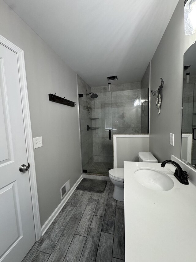 full bath featuring wood finish floors, visible vents, toilet, a stall shower, and vanity