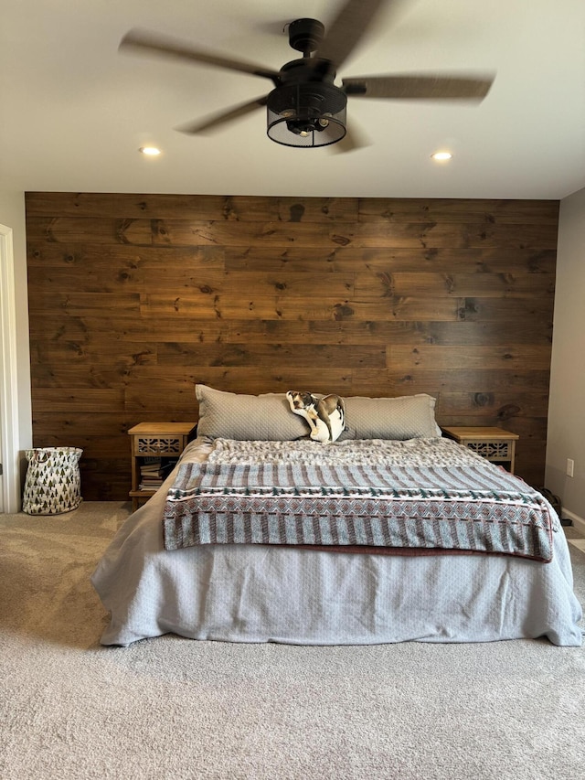 unfurnished bedroom featuring recessed lighting, wooden walls, ceiling fan, and carpet