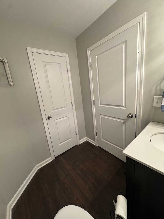 bathroom with vanity, baseboards, and wood finished floors