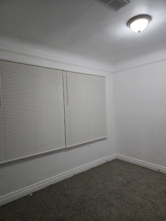 empty room featuring visible vents, carpet floors, and baseboards