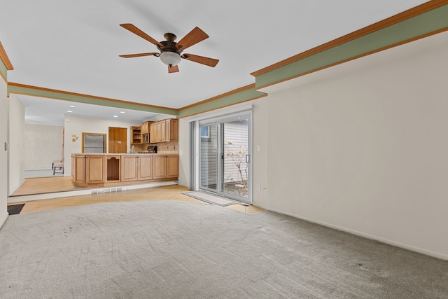 unfurnished living room featuring ceiling fan, baseboards, ornamental molding, light carpet, and recessed lighting