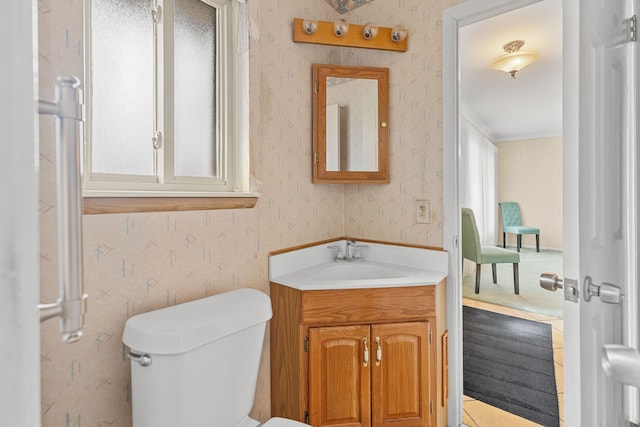 bathroom featuring wallpapered walls, vanity, toilet, and a healthy amount of sunlight