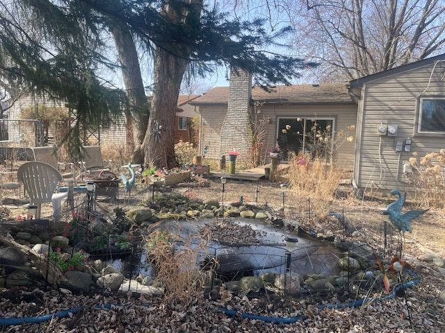 exterior space featuring a fire pit, a garage, and a chimney