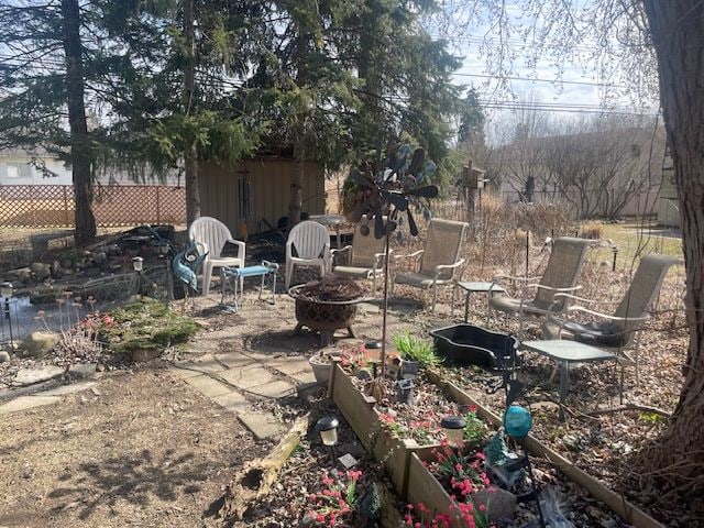 view of yard featuring a patio, a fire pit, and fence