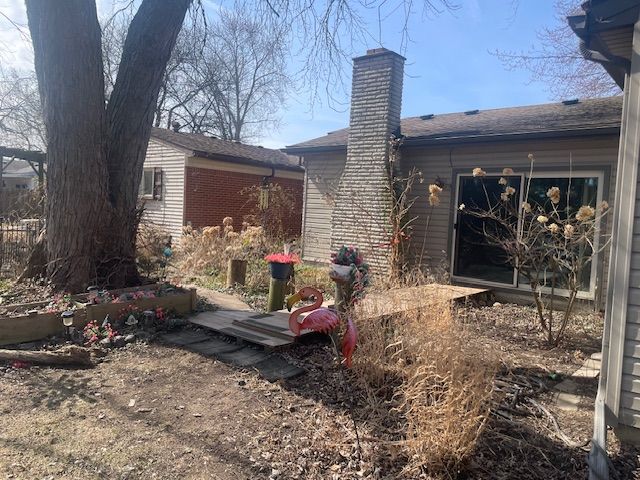 back of property with brick siding and a chimney