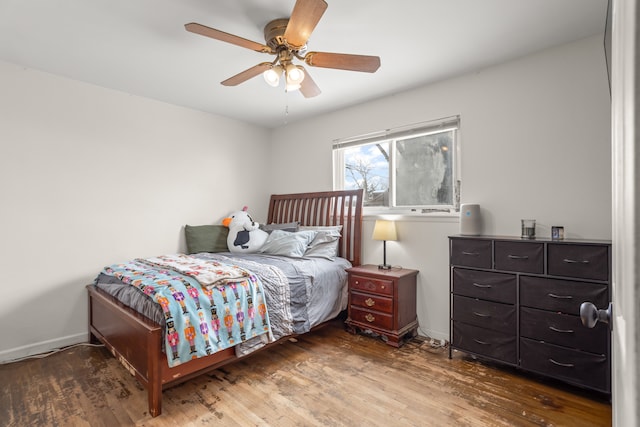 bedroom featuring a ceiling fan, wood finished floors, and baseboards