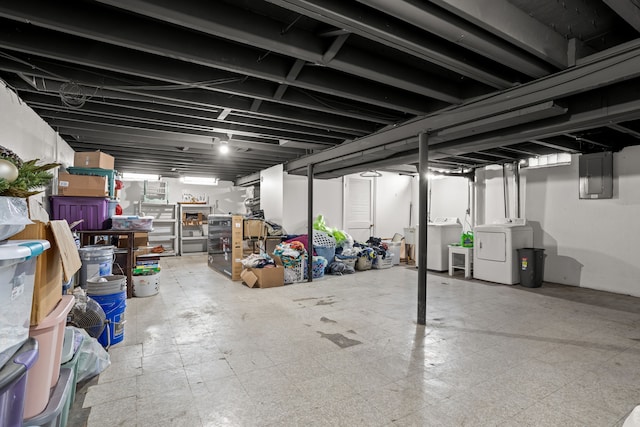 unfinished below grade area featuring washer and clothes dryer, tile patterned floors, and electric panel