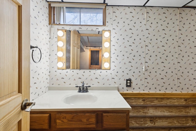 bathroom with wallpapered walls and vanity