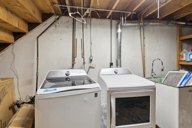 washroom with a sink, laundry area, and washer and clothes dryer