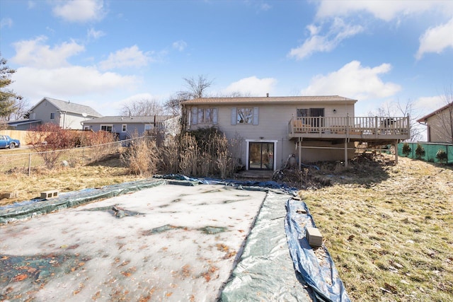 rear view of house with a wooden deck, a patio area, and fence