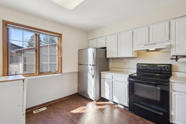 kitchen with visible vents, under cabinet range hood, light countertops, freestanding refrigerator, and electric range