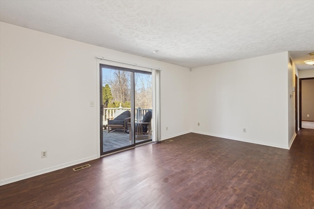 spare room with dark wood finished floors, baseboards, visible vents, and a textured ceiling