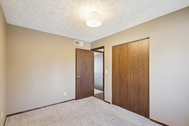 unfurnished bedroom featuring a closet, visible vents, carpet flooring, and baseboards