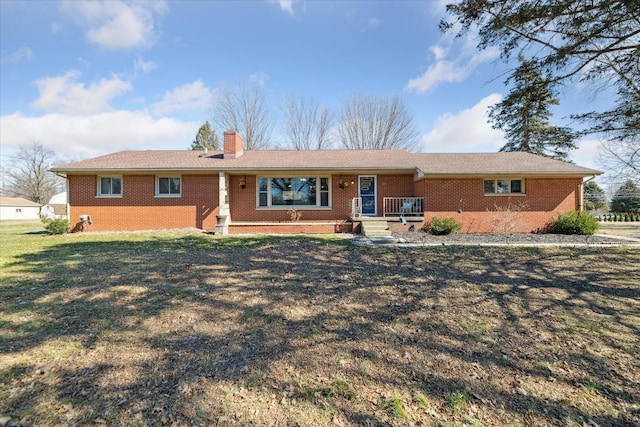 ranch-style home featuring brick siding, a front lawn, and a chimney