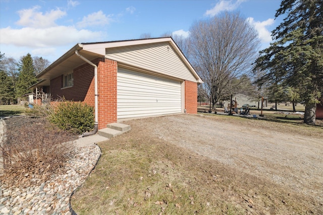 view of home's exterior featuring brick siding and driveway