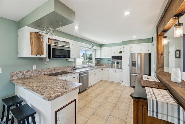 kitchen featuring light tile patterned floors, appliances with stainless steel finishes, a peninsula, white cabinets, and a sink