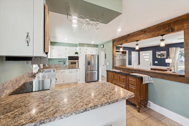 kitchen with a sink, white cabinetry, stainless steel appliances, a peninsula, and baseboards