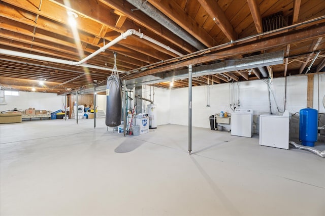 basement featuring water heater and independent washer and dryer