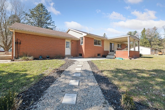 rear view of house featuring a yard and brick siding