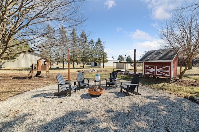 view of yard featuring a fire pit, a storage shed, and an outdoor structure