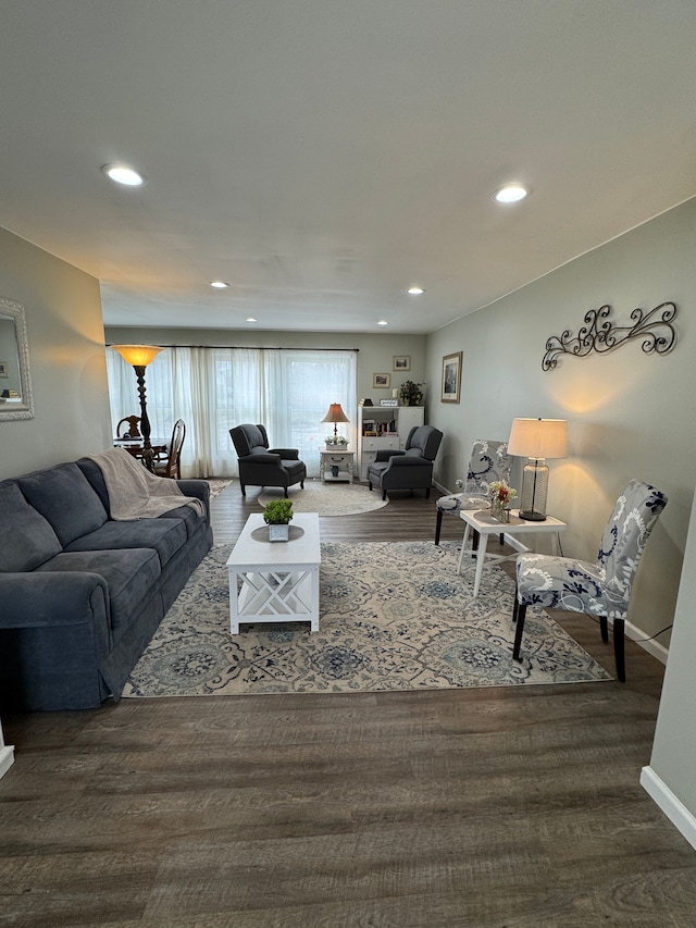 living area featuring recessed lighting, baseboards, and dark wood-type flooring