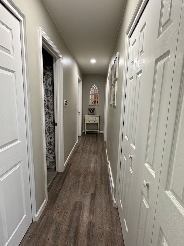 hall featuring dark wood-style floors and baseboards