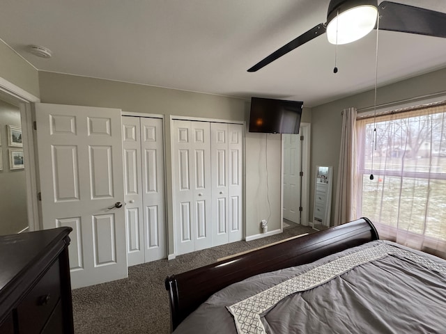 carpeted bedroom with ceiling fan and multiple closets