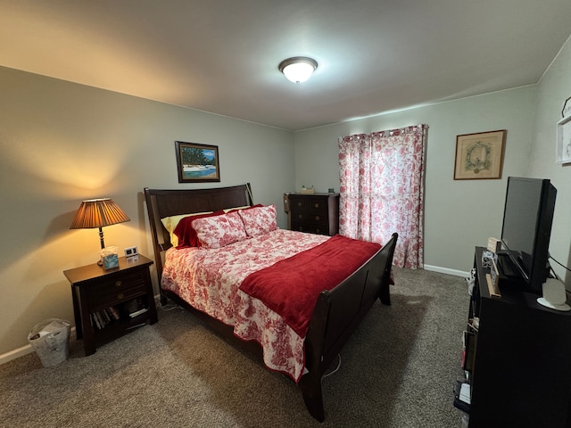 bedroom featuring baseboards and dark carpet