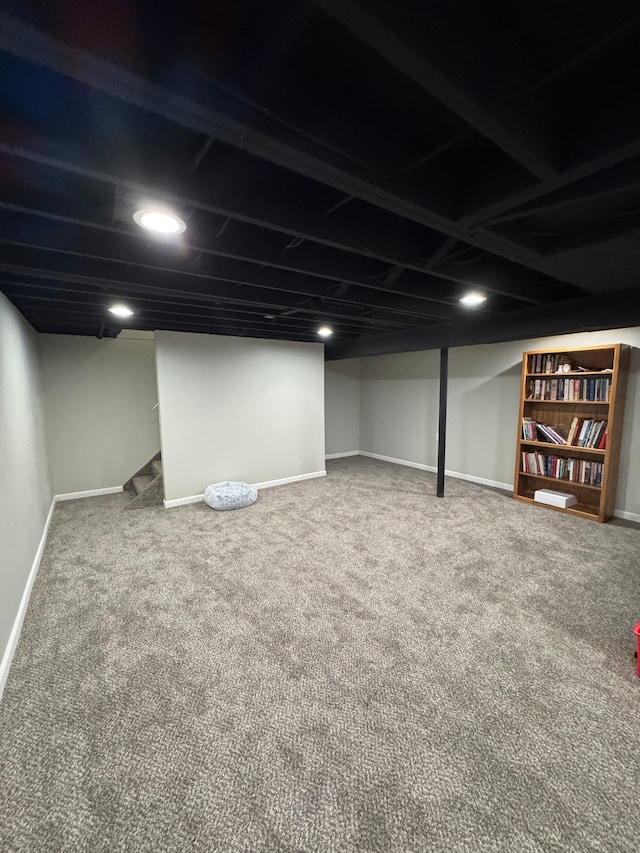 finished below grade area featuring baseboards, carpet floors, and stairs