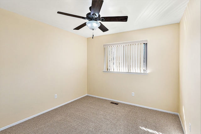 carpeted empty room with visible vents, ceiling fan, and baseboards