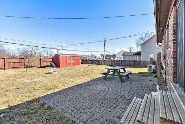 view of patio / terrace with a storage shed, an outdoor structure, and a fenced backyard