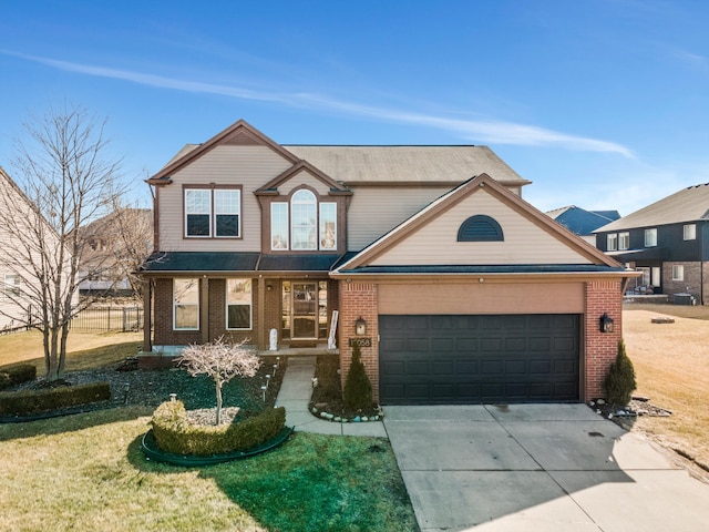 traditional-style house with a front yard, a garage, brick siding, and driveway