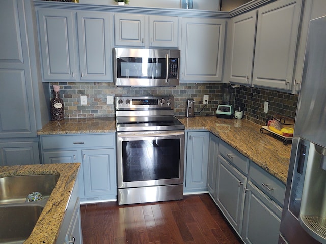 kitchen with dark wood finished floors, backsplash, gray cabinets, and stainless steel appliances