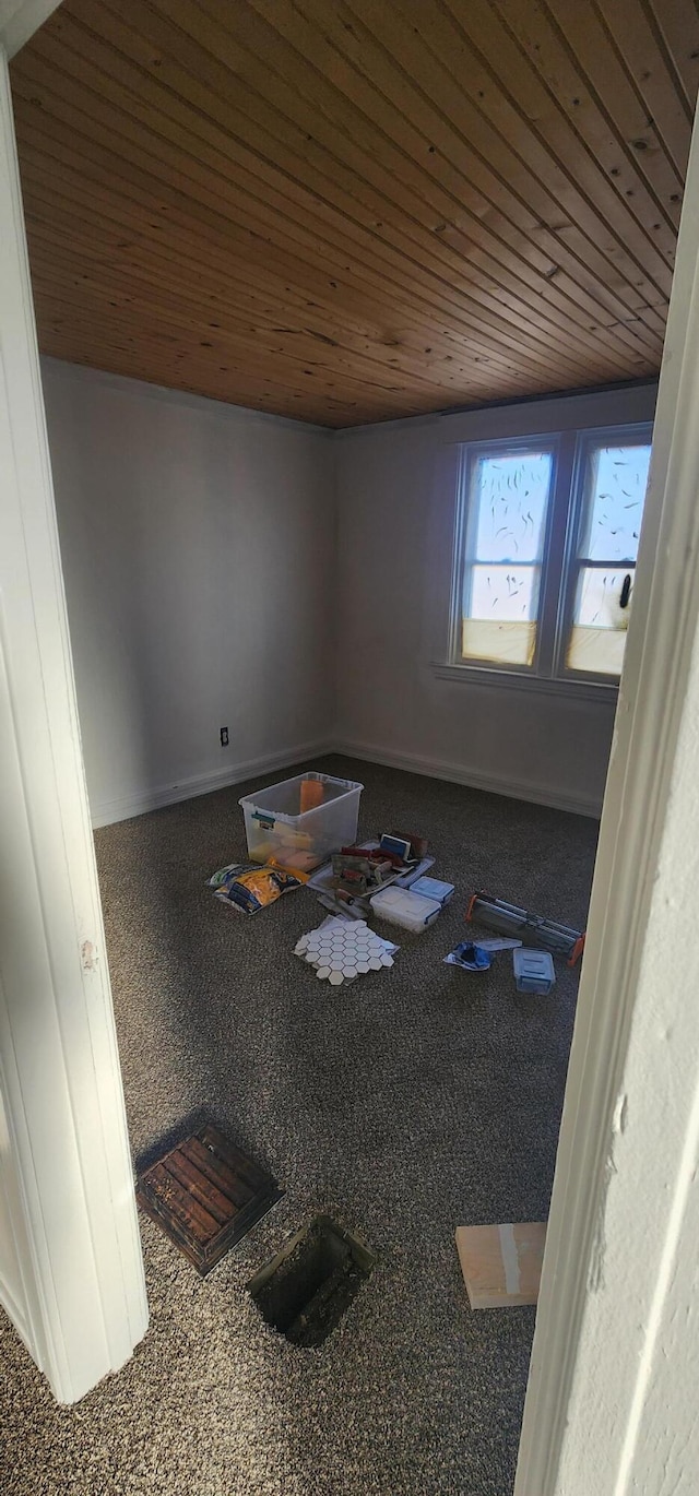 interior space featuring wood ceiling and baseboards