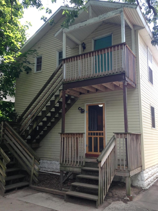 rear view of house featuring a balcony and stairway