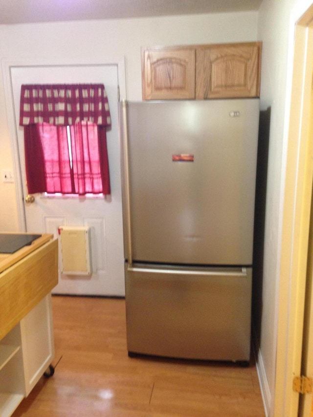 kitchen with light wood finished floors and freestanding refrigerator