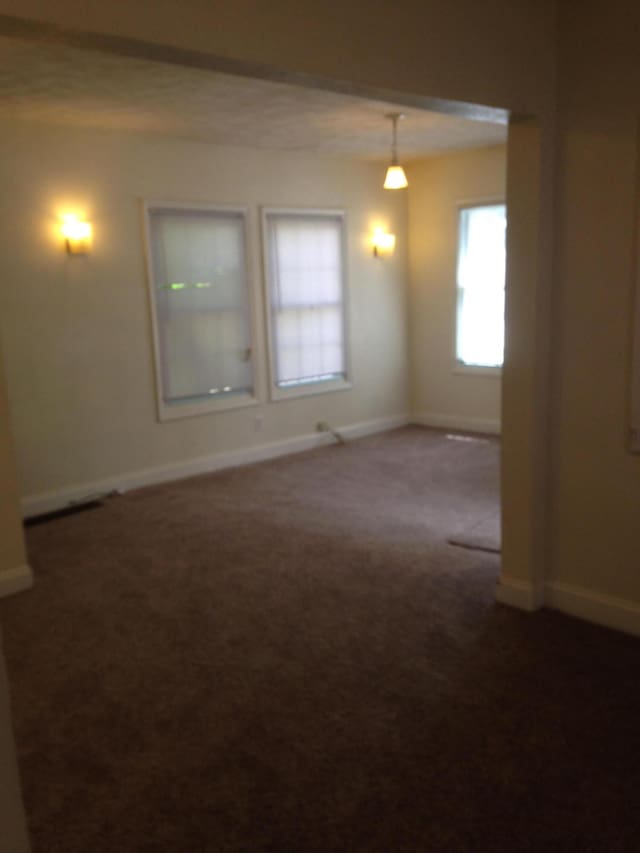 spare room featuring baseboards and carpet flooring