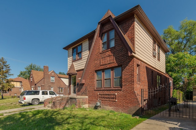 view of side of home with brick siding and a lawn