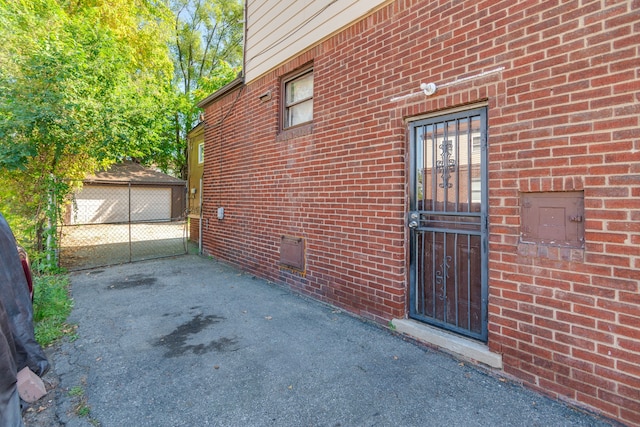 property entrance featuring brick siding, crawl space, and a detached garage