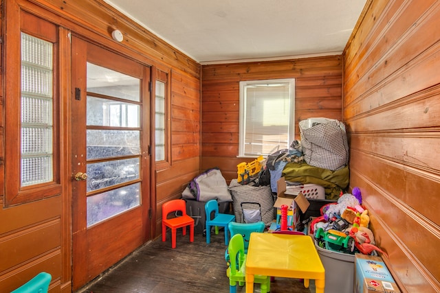 recreation room with wooden walls and wood finished floors