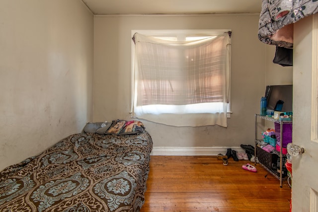 bedroom with hardwood / wood-style flooring and baseboards