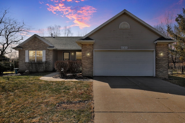 single story home with driveway, a shingled roof, a front yard, an attached garage, and brick siding