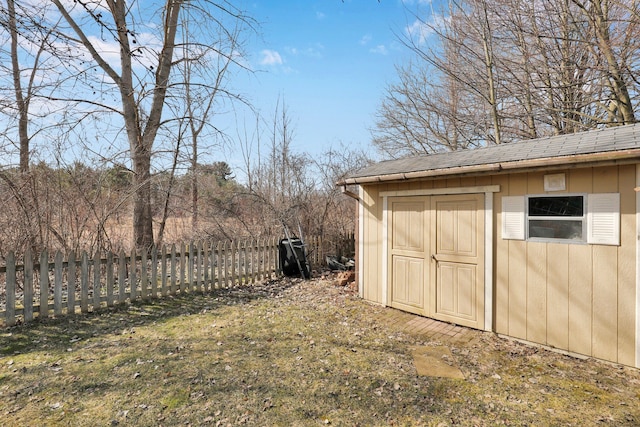 view of yard featuring an outbuilding, fence, and a shed