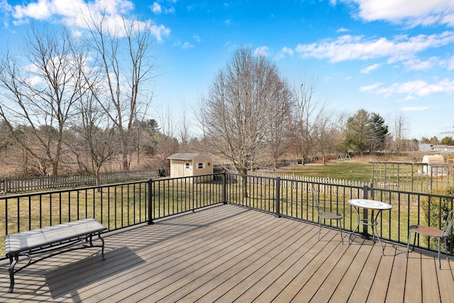 wooden deck with a storage unit, an outbuilding, and a yard