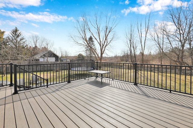 wooden terrace featuring a yard and fence