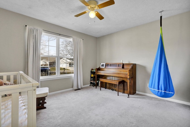 bedroom with ceiling fan, carpet flooring, baseboards, and a textured ceiling