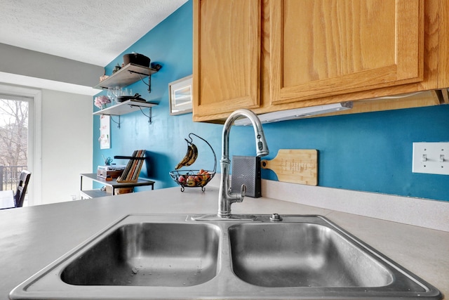 details with open shelves, a textured ceiling, light countertops, and a sink