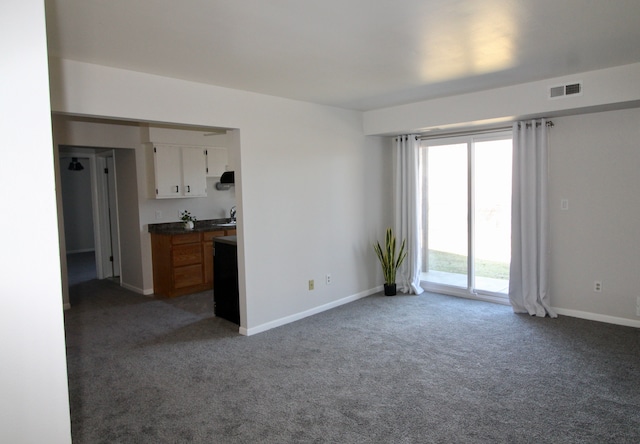 interior space with baseboards, visible vents, carpet floors, and a sink