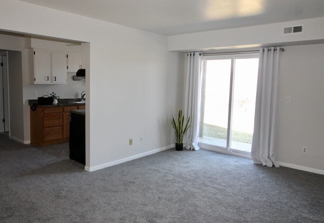 interior space featuring a sink, visible vents, baseboards, and carpet