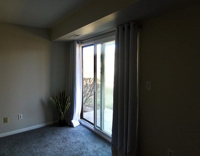 spare room with carpet flooring, visible vents, and baseboards